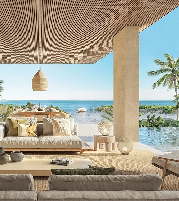 Beachfront outdoor lounge with neutral-toned furniture and ocean views, showcasing relaxed luxury living.