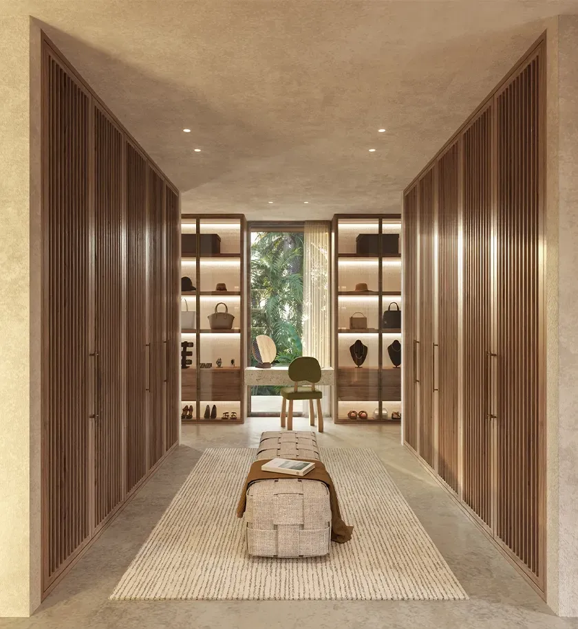 High-end walk-in closet with wooden cabinetry, soft lighting, and garden view in Punta Cana luxury villa.