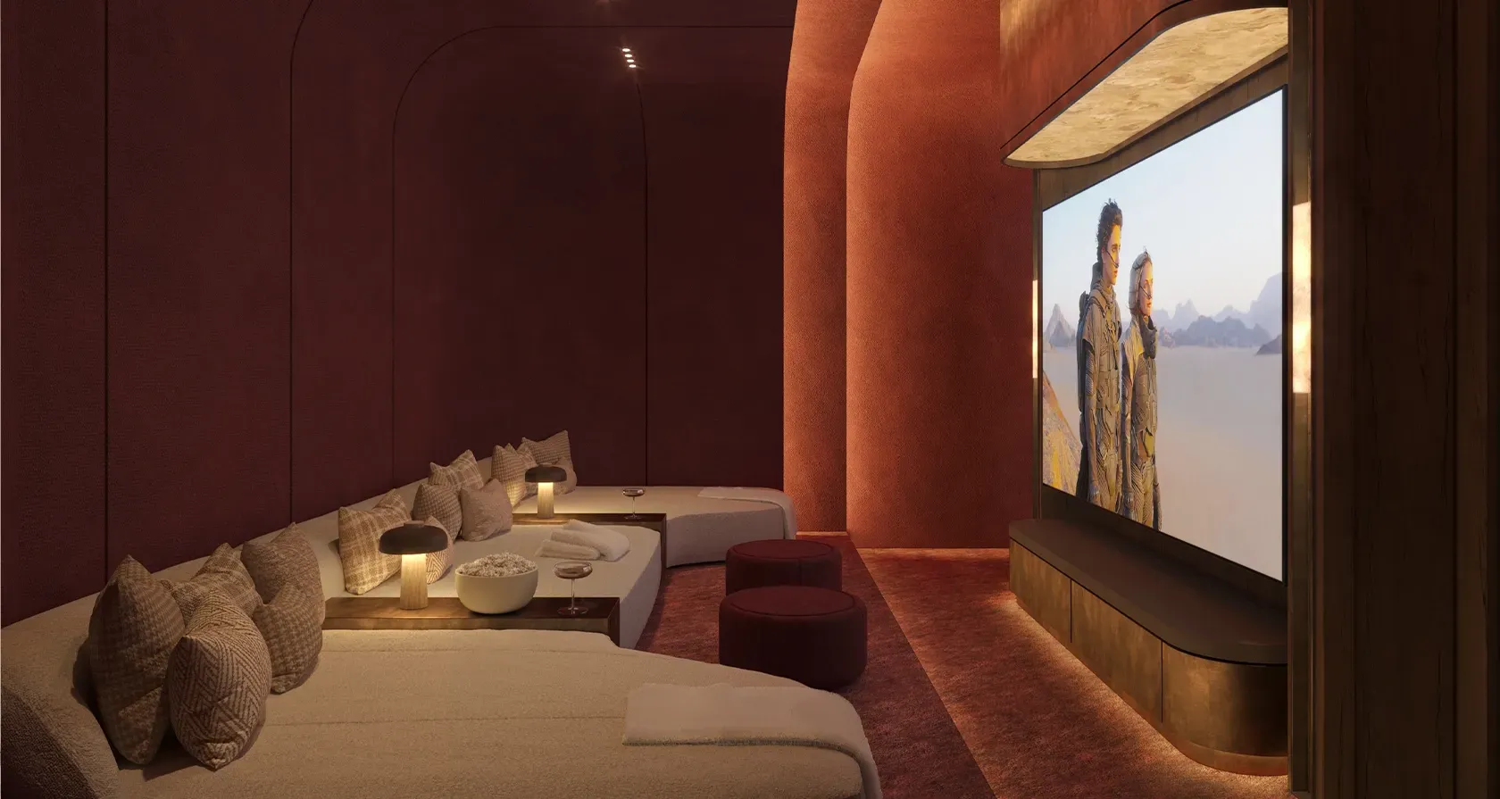 Private home cinema with plush seating, moody lighting, and luxury design featuring a large curved screen.