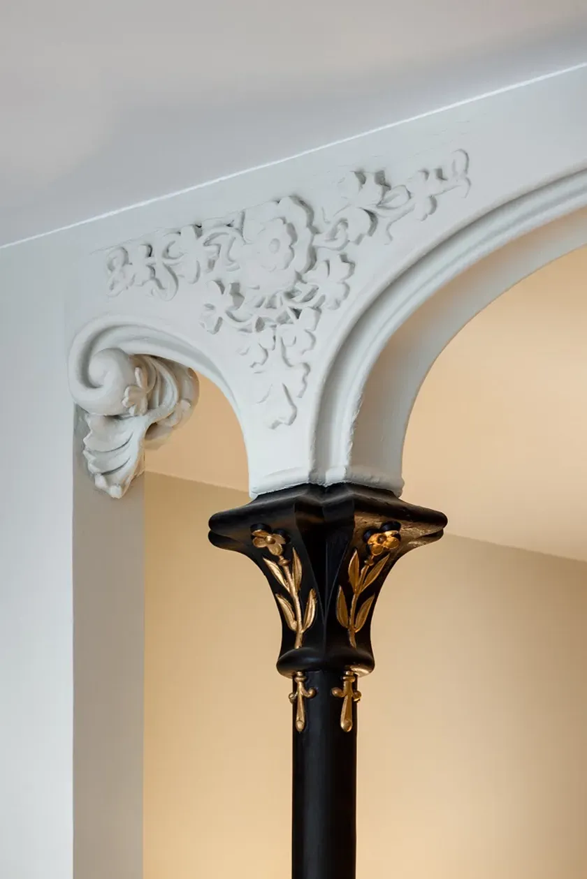 Ornate black and white capital with golden floral details, architecture by LUV Studio.