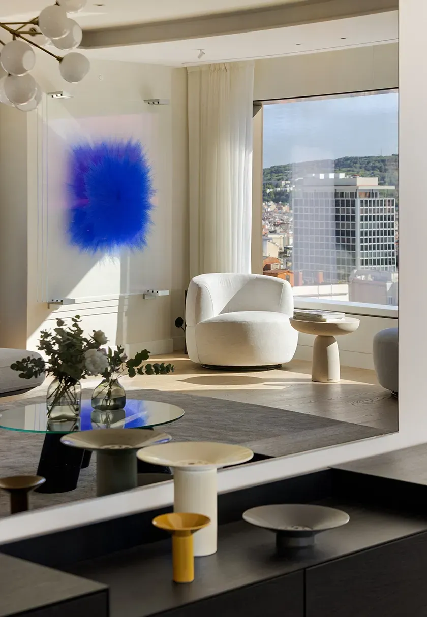 Bright lounge area with designer armchair and striking blue artwork, offering city views from Mandarin Oriental Residences.