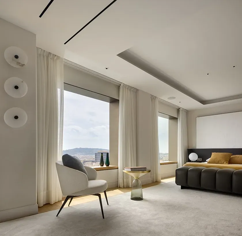 Refined bedroom suite with plush seating, large windows, and curated decor at Mandarin Oriental Residences.